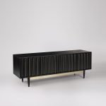 Foxe TV Stand in black-stained mango wood with scalloped facade and brass detailing