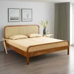 Solid wood wicker rattan bed in a calm, earthy bedroom interior
