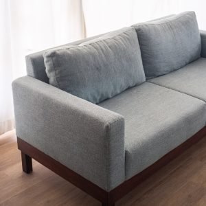 Modern Minimalist 2-Seater Sofa in light grey fabric with clean lines and tapered wooden legs in a stylish living room