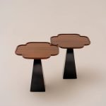 Blom Table with sculptural wooden legs and smooth curved edges in a minimalist living space