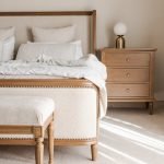 Emperor size solid wood bed frame with tall headboard and natural wood grain finish in a spacious bedroom