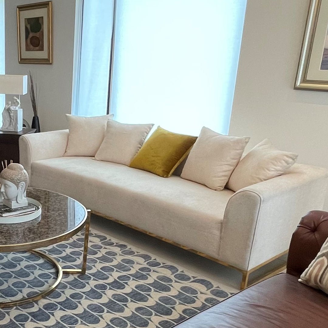 Luxurious sofa with velvet upholstery and handcrafted MS gold leaf base in a modern living room