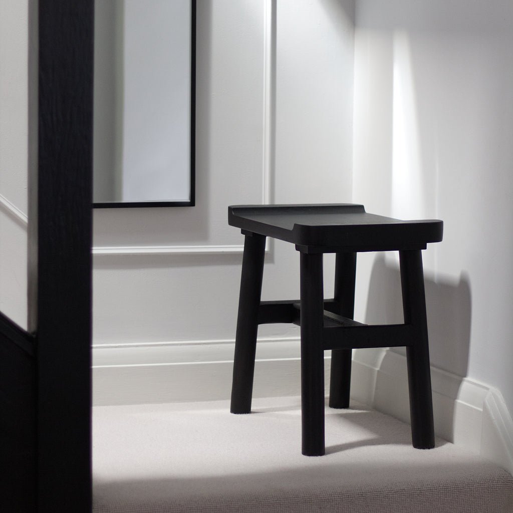 Kettil Milking Stool in black solid wood with three-legged rustic design