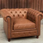 Classic Chesterfield Sofa in tufted brown leather with rolled arms in a vintage living room