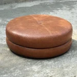 Leather Donut Ottoman in cognac brown with circular hollow design on a modern rug