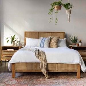 Mitra Rattan Bed showcasing solid teak wood frame with woven rattan headboard and footboard in a minimalist bedroom setting.