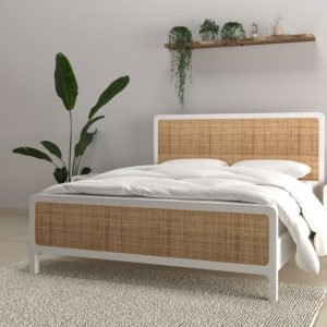 Solid wood bed with rattan cane headboard and footboard in a minimalist bedroom setting.