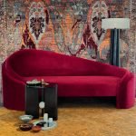 Crimson Curve Sofa with plush velvet upholstery and rounded sculptural design in a modern living room