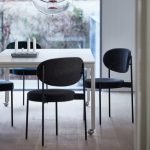 Dark wood dining chair with upholstered seat and curved back in a contemporary dining room