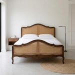 Solid wood cane panel bed with woven rattan headboard and footboard in a modern bedroom