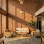 Wooden cane sofa set with beige cushions placed against a terracotta brick wall in a modern lounge setting