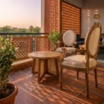 Handcrafted Teak wood armchair with an oval back and cream cushion upholstery on a sunlit balcony.