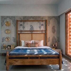 Royal wooden bed with cane headboard placed in a heritage-style bedroom with artistic wall patterns and natural sunlight.