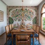 Wooden dining table set with cane chairs placed in a heritage-style dining room with colorful wall mural and natural lighting.